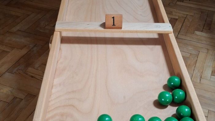 Japanisches Billard – Bahn im Saal mit den grünen Kugeln, vorne die nummerierten Vertiefungen