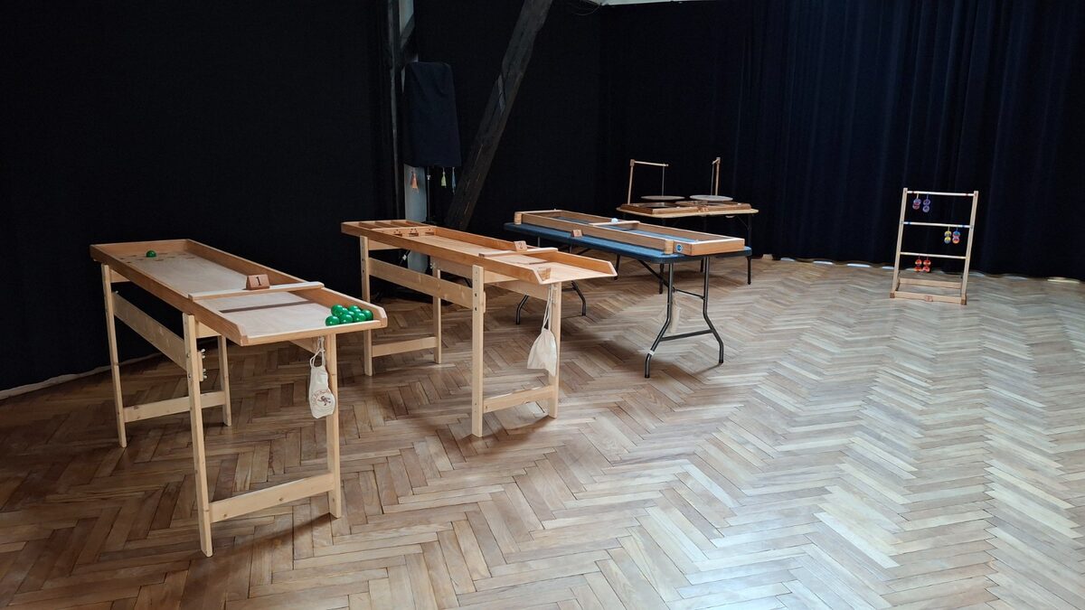 Aufbau im Saal: Japanisches Billard, Shuffleboard/Jakkolo, Schibbelmühle, Bomboleo und Leitergolf auf dem Parkett