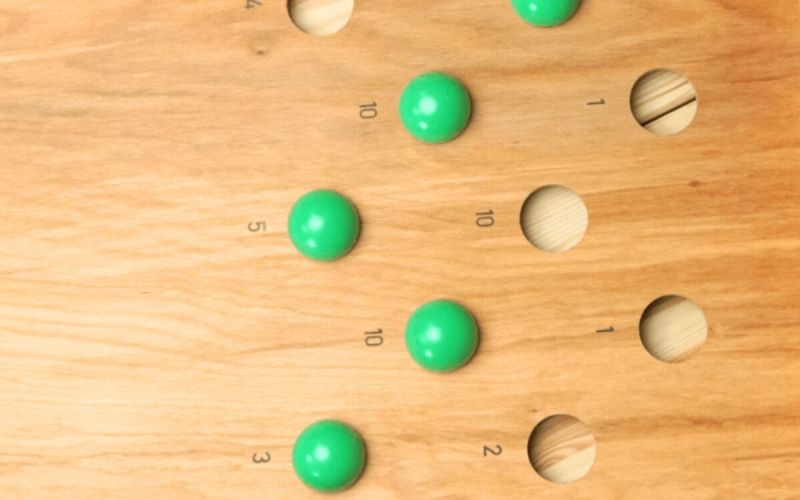 Japanisches Billard: grüne Kugeln in den Vertiefungen mit Punktwerten